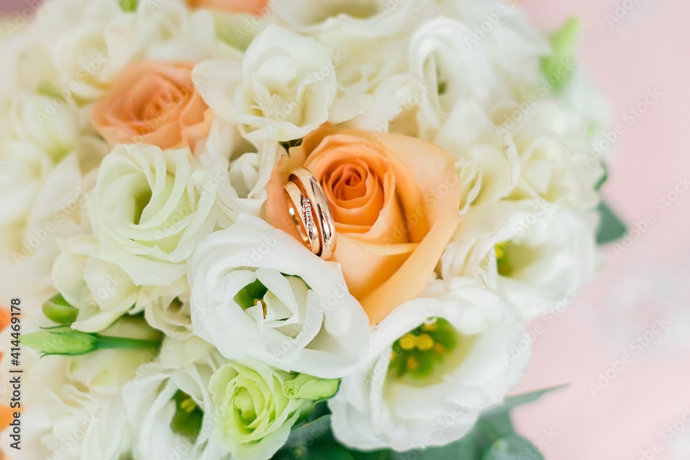 Fototapeta premium Wedding rings on the background of the bride's bouquet. Close-up. Soft focus.