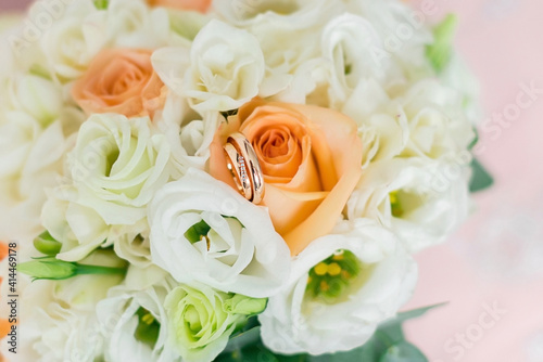 Wedding rings on the background of the bride s bouquet. Close-up. Soft focus.