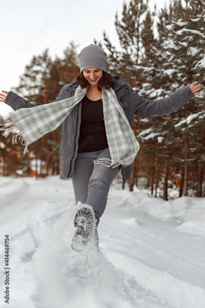 Girl Walking On The Snow With Boots, Young woman kicks snow with her foot on winter road in forest Girl Walking On The Snow With Boots, Young woman kicks snow with her foot on winter road in forest