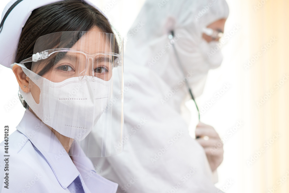 Portrait of Thai female nurse wearing protective mask and face shield in hospital. Young Asian medical staff in white uniform. Healthcare concept. copy space Portrait of Thai female nurse wearing protective mask and face shield in hospital. Young Asian medical staff in white uniform. Healthcare concept. copy space