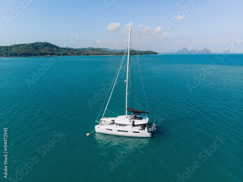 Top view of a beautiful expensive sailing yacht in the middle of the sea with a huge amount of blue space around against the backdrop of the sky and nature