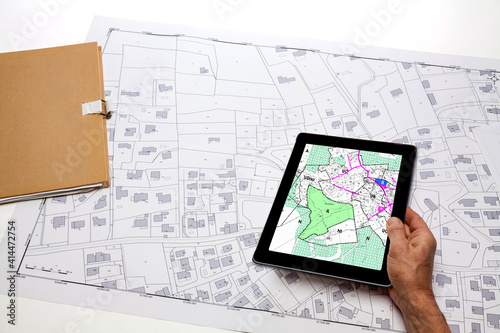 Urbanisme et Aménagement du territoire - tablette numérique affichant une carte de projet d'urbanisme sur fond de plan cadastral