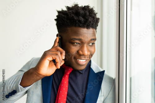 handsome young african man in suit with mobile phone 