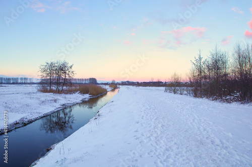 Winter landscape in The Netherlands with beautiful colored sunset sky and fresh white snow, beauty nature background