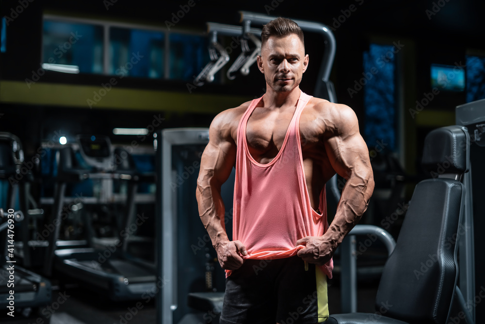 Naklejka premium young sportsman bodybuilder with muscle body have workout in gym