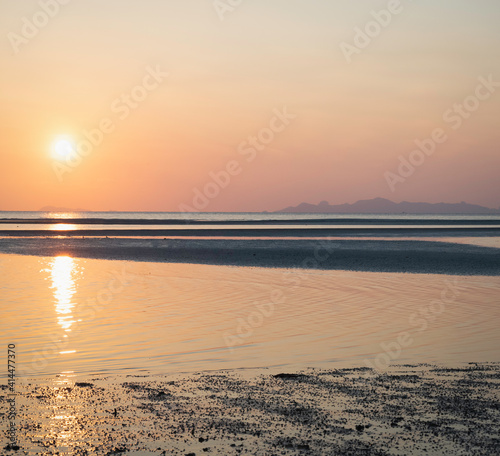 Pastel color of Sky background and Sea beach in morning time,reflection of sunrise shining around