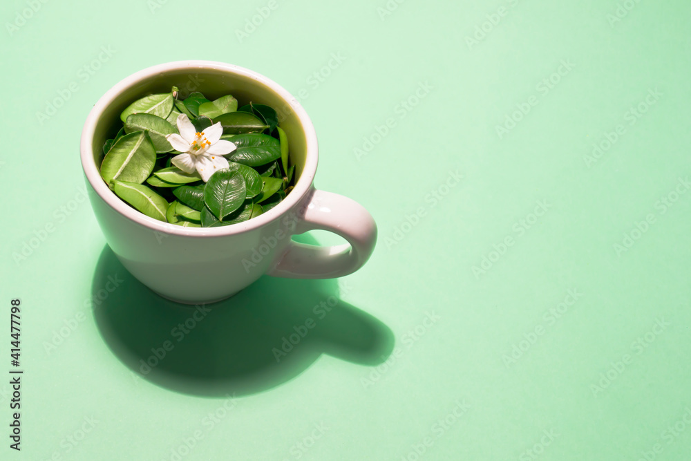 Taza rellena de hojas con pequeña flor Taza rellena de hojas con pequeña flor