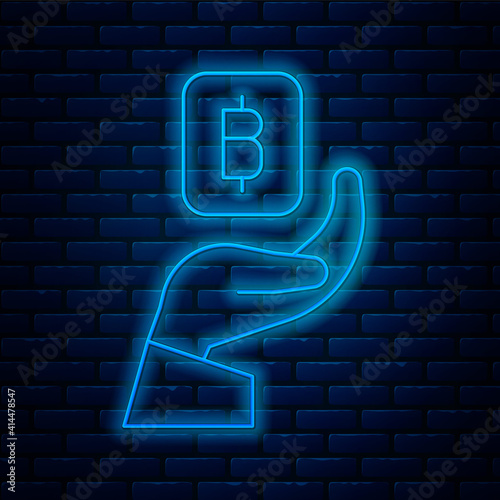 Glowing neon line Hand holding Bitcoin icon isolated on brick wall background. Blockchain technology, digital money market, cryptocoin wallet. Vector.
