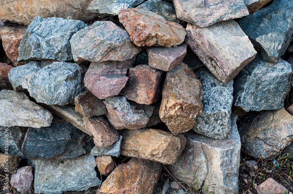 Roughly heaped granite stones, outdoor weathered material, large building blocks. Close-up. Roughly heaped granite stones, outdoor weathered material, large building blocks. Close-up.