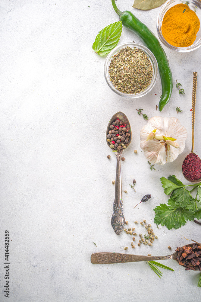 Fresh herbs, dried colorful spices. Cooking background flatlay with variety spices, herbs pepper, vanilla bean, cinnamon, basil, rosemary, chilli red green peppers, mint, parsley White table top view Fresh herbs, dried colorful spices. Cooking background flatlay with variety spices, herbs pepper, vanilla bean, cinnamon, basil, rosemary, chilli red green peppers, mint, parsley White table top view