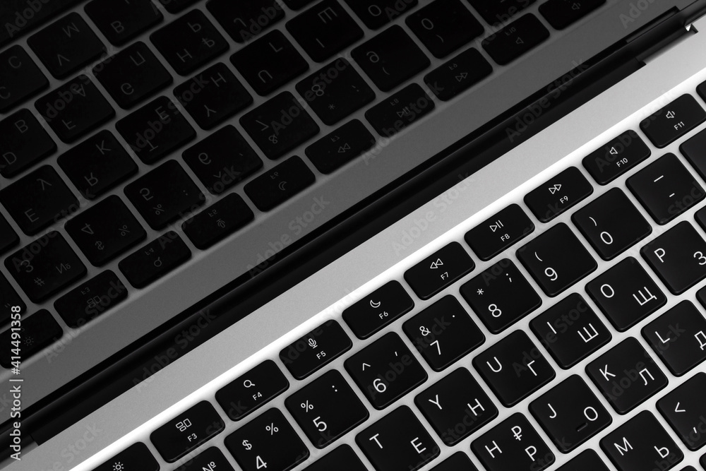 a fragment of a laptop keyboard, black buttons with white letters are reflected in the screen a fragment of a laptop keyboard, black buttons with white letters are reflected in the screen