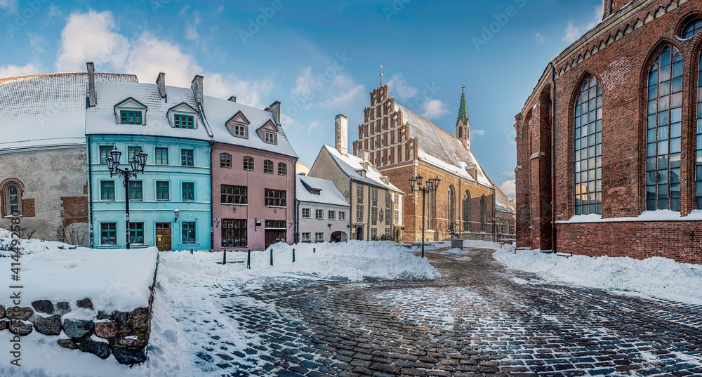 Covered in snow street in historic city center in Riga. Historic houses near Saint Peter's church in winter in Riga, Latvia