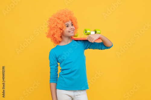 skateboarder. cheerful child holding penny board. teen girl with fancy hairstyle.