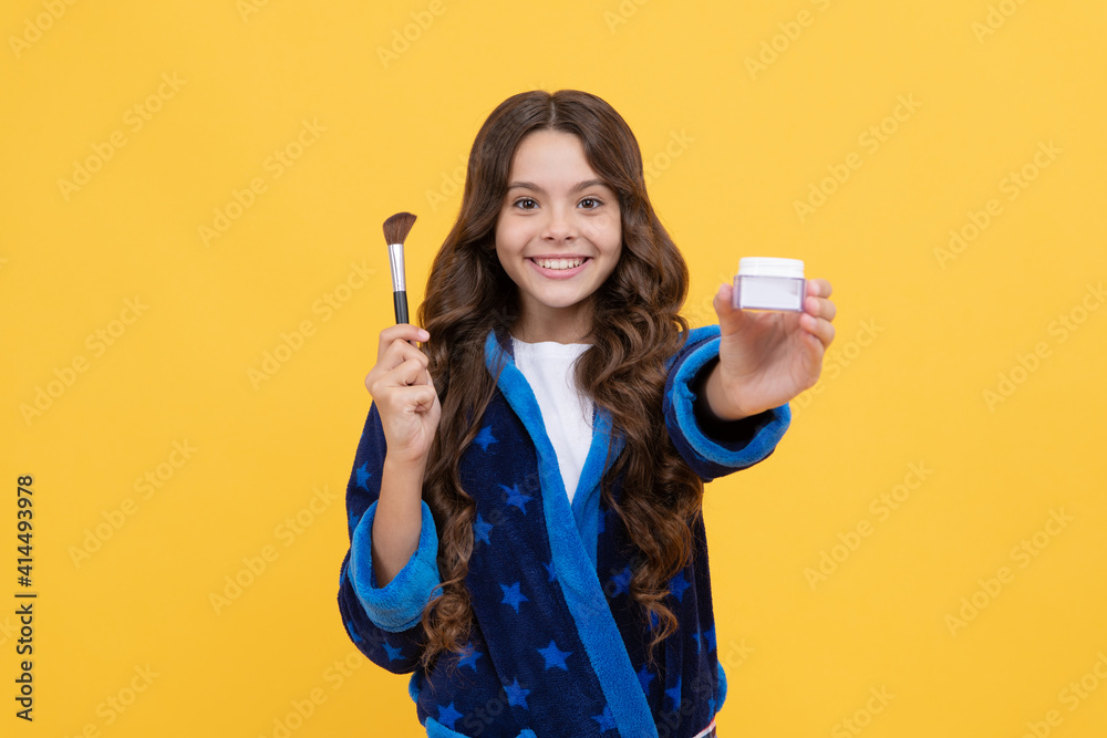 happy child girl in cozy bathrobe grooming with powder brush, presenting product happy child girl in cozy bathrobe grooming with powder brush, presenting product