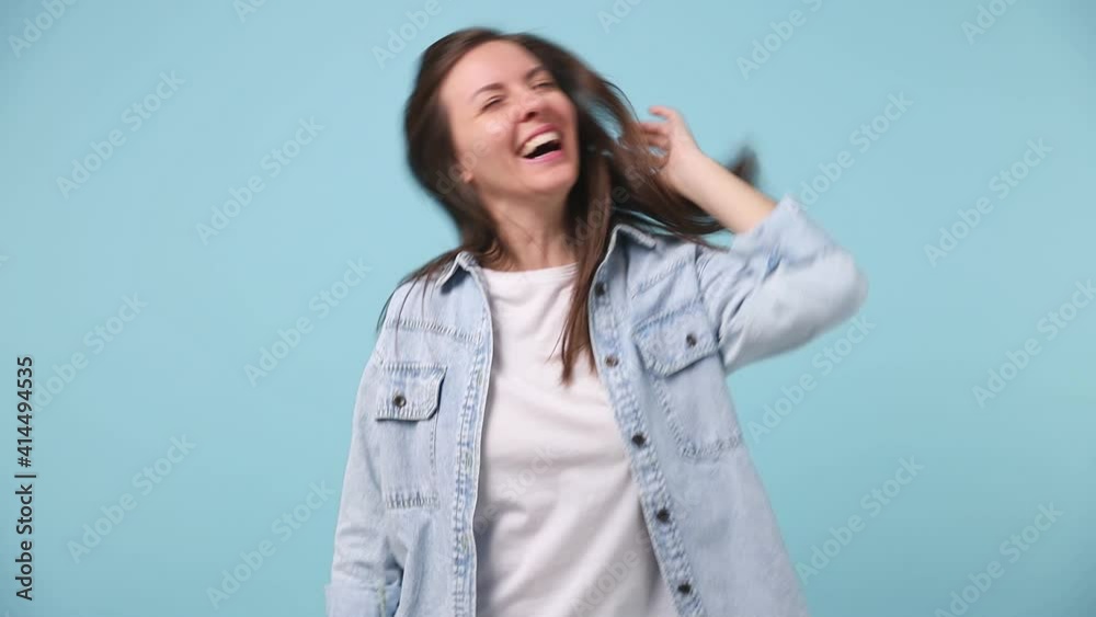 Slow motion fancy vivid bright beautiful long hair young woman 30s years old in denim jacket white t-shirt dance fool around having fun gesticulate with hands isolated on pastel blue background studio Slow motion fancy vivid bright beautiful long hair young woman 30s years old in denim jacket white t-shirt dance fool around having fun gesticulate with hands isolated on pastel blue background studio
