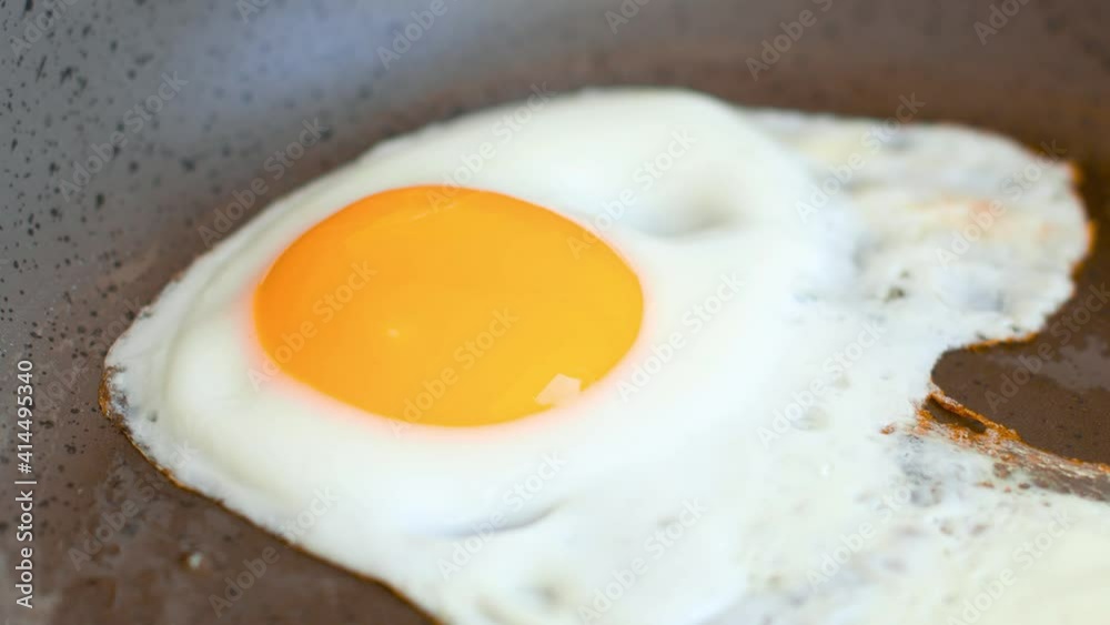 Frying an egg in a frying pan on a hot stove. Close up fried eggs in a pan. Frying an egg in a frying pan on a hot stove. Close up fried eggs in a pan.