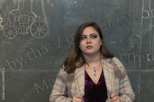 Portuguese straight hair woman next to a dark wall