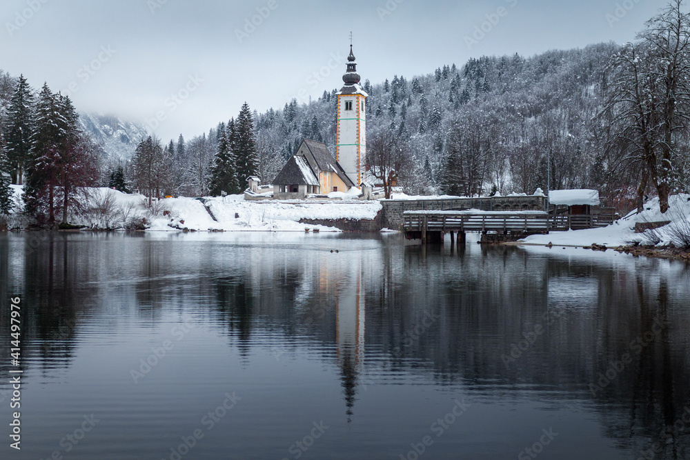 Old church at Lake Bohinj in winter snow, Slovenia