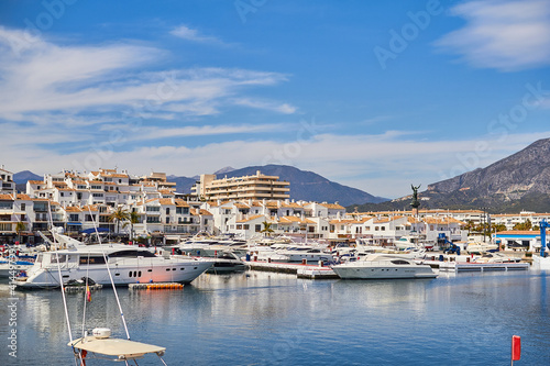 View of Puerto Banus marina with boats and white houses in Marbella town at sunrise  Andalusia  Spain