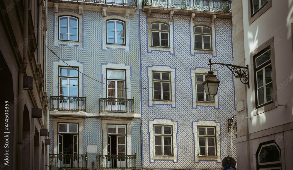 Facade of an ancient building covered with ceramic tiles typical for Portuguese traditional architectural style.