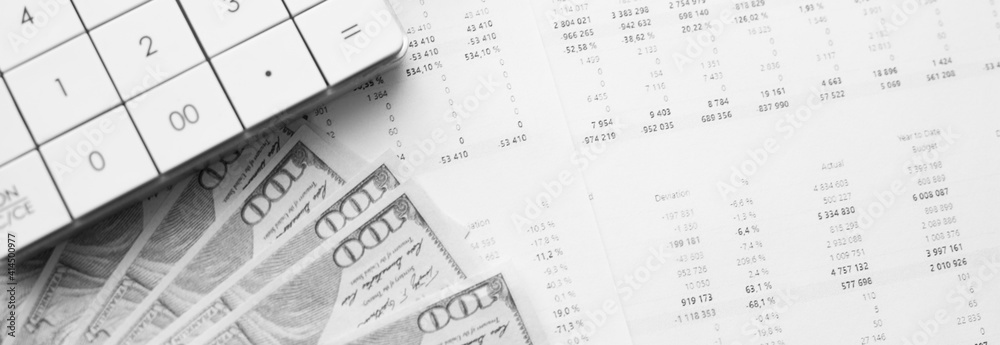 Fototapeta premium Calculator with money on financial data. Business and financial concept.