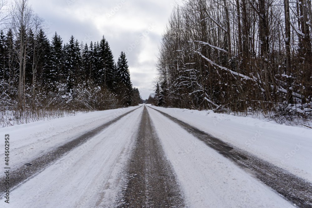 beautiful sunny winter day in Latvia where the asphalt is frozen and there are rails on it where you can see small asphalt stones and snowy beautiful sunny winter day in Latvia where the asphalt is frozen and there are rails on it where you can see small asphalt stones and snowy