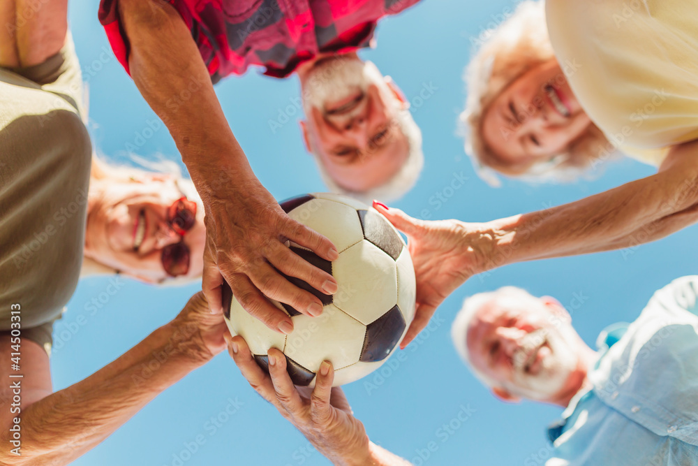Fototapeta premium Senior people holding a soccer ball