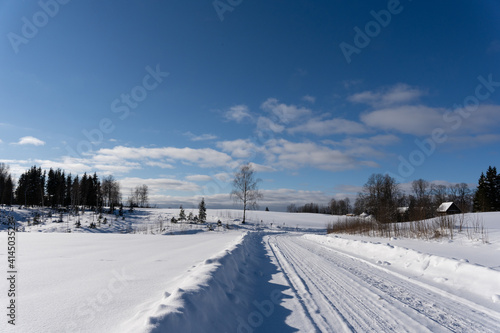  road in the middle of the field that is covered with snow