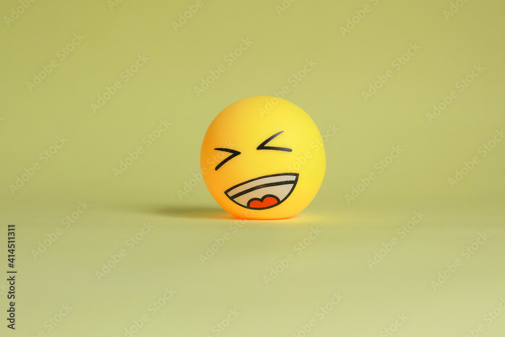Laugh emoticon isolated on yellow background.
