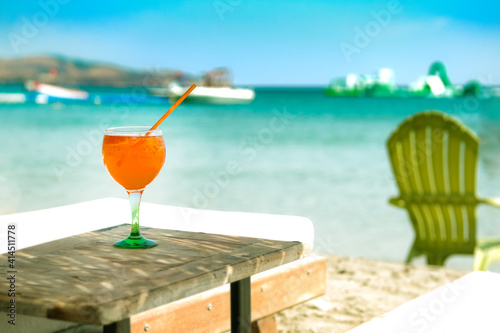 Orange cocktail in glass on the beach club at the sea