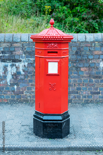 Red post box in city centre of Birmingham, United Kingdom. British style red post box. Traditional red post box in UK.