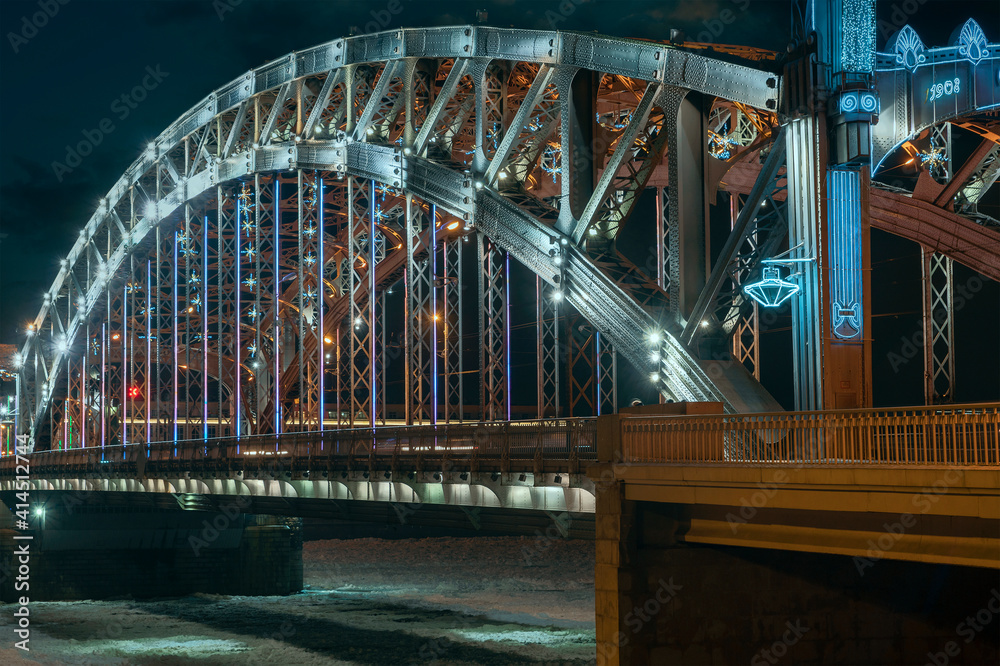 Obraz premium the beautiful metal bridge of Peter the Great across the Neva River in St. Petersburg against the night sky