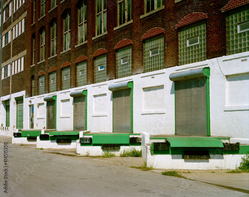 A row of empty loading docks with green trim making an interesting design in an industrial area of the west Bottoms of Kansas City Missouri in the 1990s. © Curtis