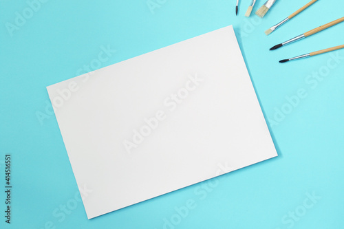 blank a4 paper sheet with paint brushes, mockup for arts