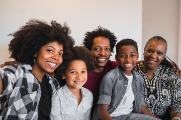 Multigenerational family taking selfie at home.