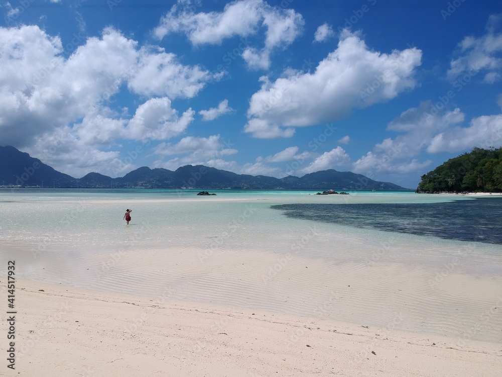 aerial view from Saint-Anne Marine National Park over white sand bar and blue sea to Mahe Island blue sky and white clouds