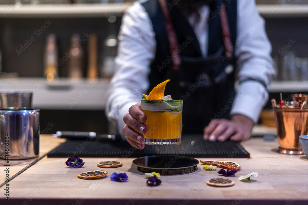 Expert barman is making cocktail at night club. Expert barman is making cocktail at night club.