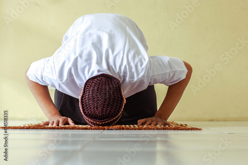 Canvas Print Front view of muslim man doing Salat with prostration pose on the prayer mat
