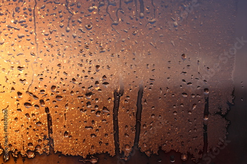 Frozen drops of condensation on a transparent glass window in the winter season with natural sunlight through the glass  high humidity  temperature difference  natural background