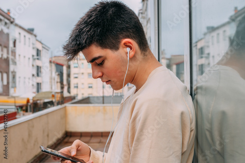 young man with phone and headphones in the city