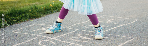 Bild auf Leinwand Closeup of child girl playing jumping hopscotch outdoors
