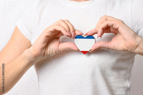 Love Crimea. A girl holds a heart in the form of a flag of Republic of Crimea on her chest. Crimean patriotism concept