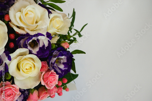 Background. Bouquet of flowers close-up on a white background. White and pink roses, blue-white eustoma. Place for text.