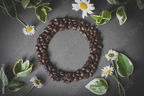 Cafes and restaurants. A mug of invigorating, black coffee and coffee beans in the shape of a heart on a dark gray background. Copy space for text. The concept of hot drinks and love.