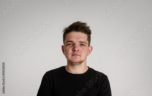 
teen guy looking at camera
seriously thinking about matters concerned on a white background in a black T-shirt
