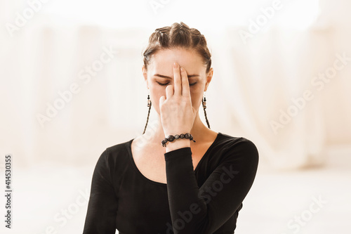 Close-up portrait of a woman practicing yoga, showing the symbol of jnana mudra on her face while breathing pranayama Nadi shodhana photo