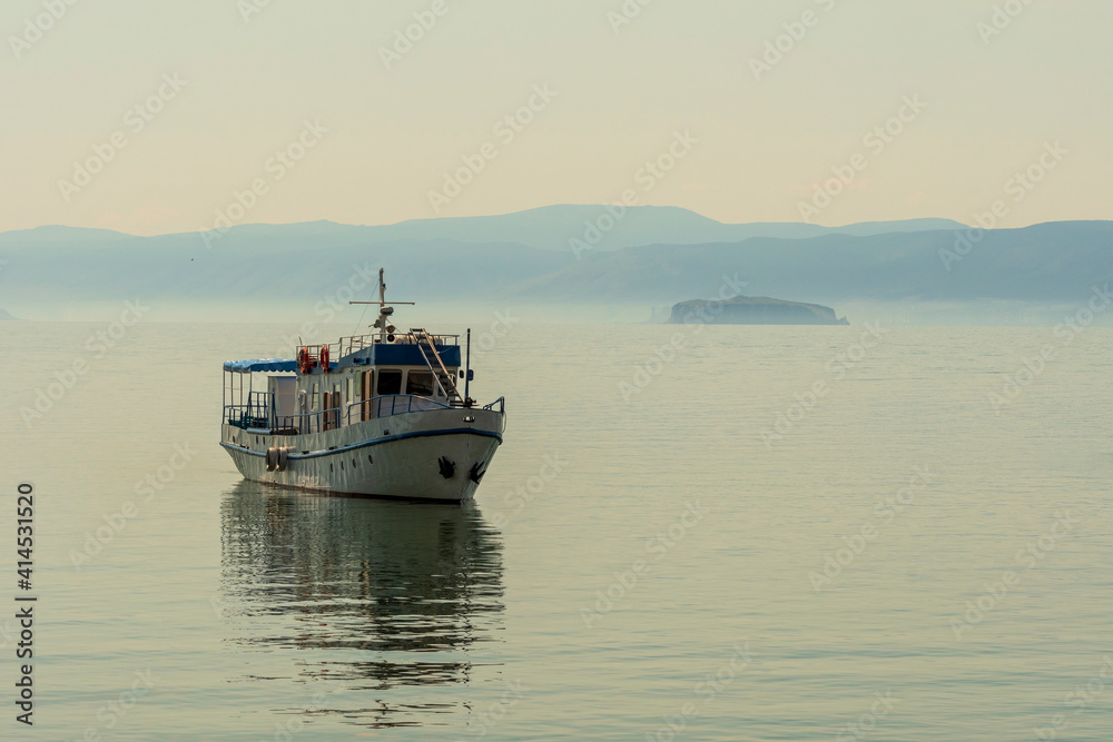 Small transport boat on Lake Baikal at sunset 