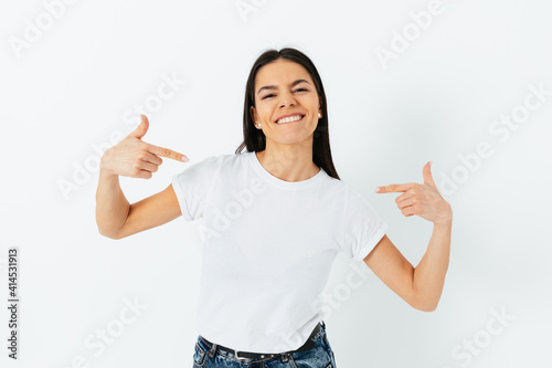 Happy confident young brunette woman pointing at herself