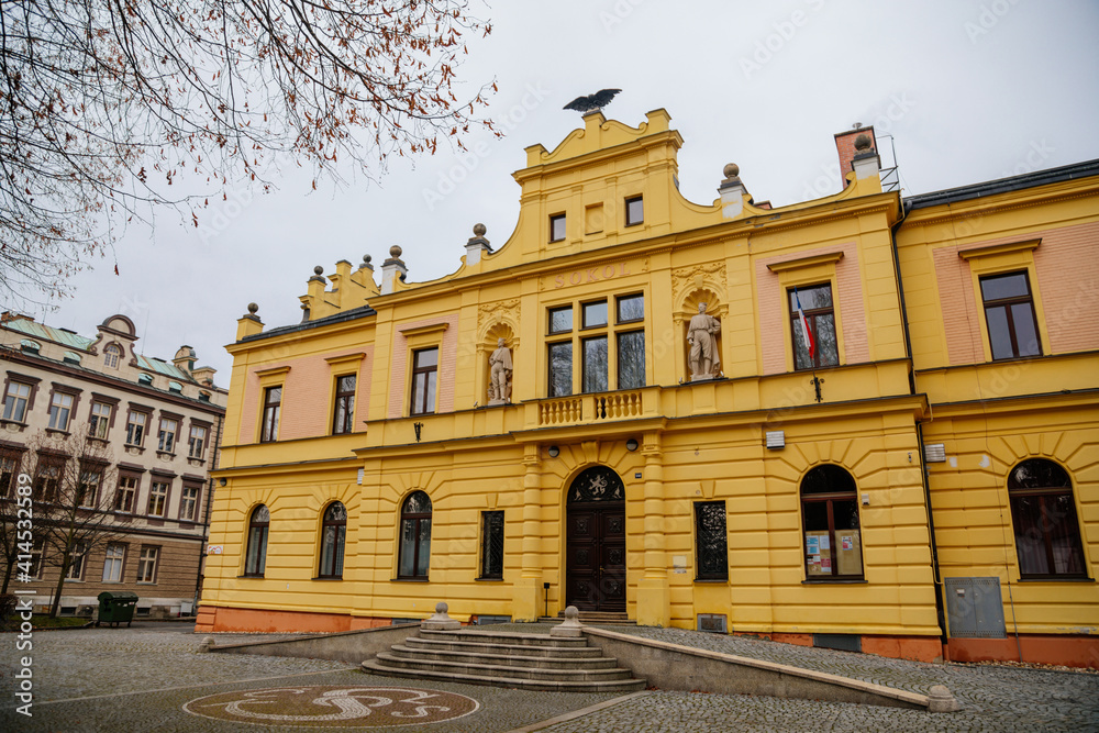 Obraz premium Neo-renaissance yellow historical building of Sokolovna, picturesque street, beautiful cityscape of medieval town in winter day, Bohemian Paradise, Turnov, Czech Republic