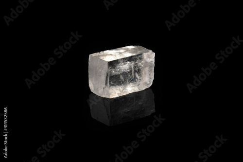 Raw Iceland spar from Krasnoyarsk region, Russia on black glass background.